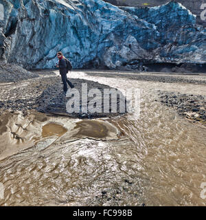 Mann steht am Sandstrand von Gigjokull-Outlet-Gletscher von Eyjafjallajokull Eiskappe. Stockfoto