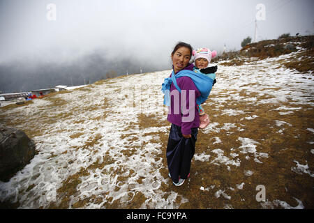 Helumbu, Nepal. 21. Januar 2016. Dawa Dolma dreißig sieben Jahre alte Frau mit ihr ein-Jahr-alte Tochter warten Winter Hilfsgüter an Helumbu ein Dorf im Bezirk Sindhupalchowk, Nepal auf Donnerstag, 21. Januar 2016 erhalten. Ein Vereinigten Staaten ansässige Hilfsorganisation Samaritan Purse versammelten Beben Überlebenden in Sindhupalchowk, Rasuwa und Nuwakot Distrikte, die die zerstörten und betroffenen Bereiche nach dem Erdbeben und Nachbeben sind Winter-Materialien für rund 6.000 Erdbeben betroffenen Familien Wert $ 1,5 Millionen. Bildnachweis: Skanda Gautam/ZUMA Draht/Alamy Live-Nachrichten Stockfoto