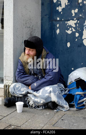 Obdachlosen Mann sitzt in einer Stadt Zentrum Tür England uk Stockfoto