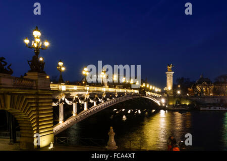 Der Pont Alexandre III, Bogenbrücke in Paris bei Nacht, Grand Palais hinter Frankreich. Stockfoto
