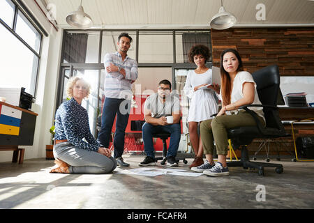 Porträt von Team kreative Menschen zusammen Blick in die Kamera. Junge Designer treffen für den Abschluss einer Projekt-Layouts. Stockfoto
