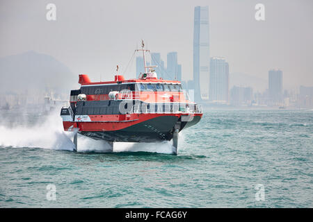 Ein TurboJET Tragflügelboot Fähre Hong Kong um seinen Weg nach Macau mit Hongkongs Stadtbild im Hintergrund zu machen. Stockfoto