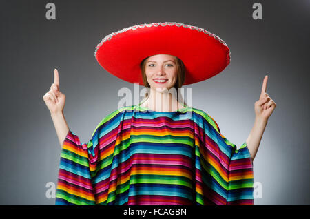 Mädchen im mexikanischen lebendige Poncho gegen grau Stockfoto