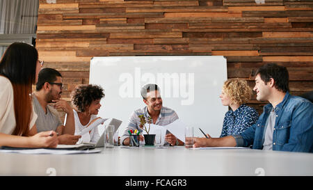 Gruppe der glückliche junge Geschäftsleute treffen im Konferenzraum. Team von Kreativ-Profis diskutieren neues Projekt. Stockfoto