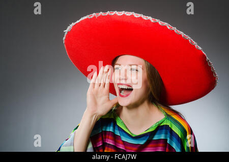 Mädchen im mexikanischen lebendige Poncho gegen grau Stockfoto