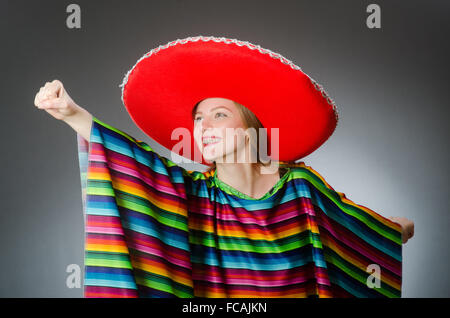 Mädchen im mexikanischen lebendige Poncho gegen grau Stockfoto