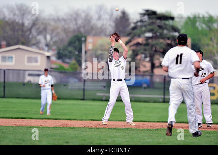 Zweiter Basisspieler Abrechnung unter einer Pop fliegen, während Sie eine Verriegelung der hitter während einer High School Baseball Spiel, in den Ruhestand zu treten. USA. Stockfoto