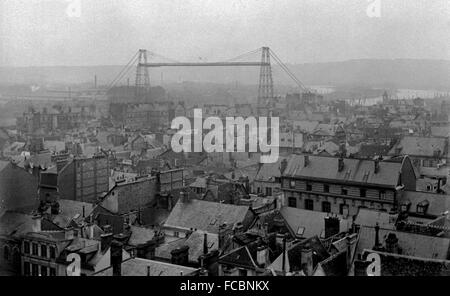 AJAXNETPHOTO.1905 (CA.). ROUEN, FRANKREICH.  -FLYING BRIDGE - EIN BLICK ÜBER DIE DÄCHER DER STADT MIT DER SCHWEBEFÄHRE ROUEN ÜBERQUERUNG DER FLUSS SEINE MITTE ENTFERNT.  FOTO: AJAX VINTAGE BILD BIBLIOTHEK REF: ROUEN 1905 56 Stockfoto