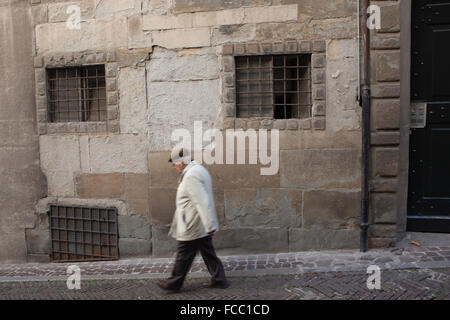 Älterer Mann zu Fuß entlang der mittelalterlichen Straße in der Citta Alta (Oberstadt) in Bergamo, Lombardei, Italien. Stockfoto