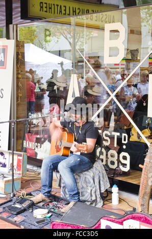 Straßenmusiker, Gesang und Gitarre in Tamworth Country Music Festival 2016 mit Zuschauern spiegelt sich im Schaufenster. Stockfoto