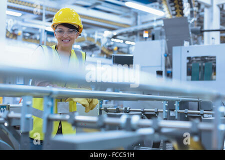 Porträt lächelnd Arbeitnehmerin bei Maschinen in der Fabrik Stockfoto