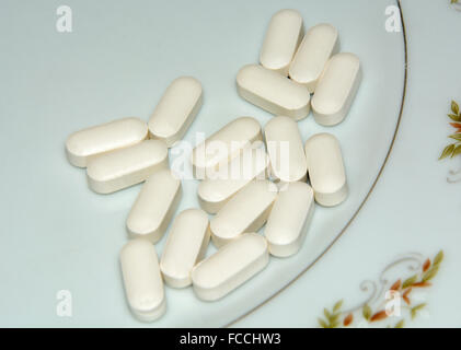 Kalzium-Tabletten auf Platte Stockfoto