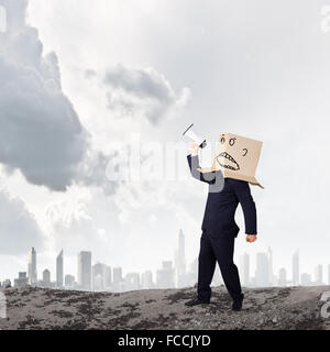 Geschäftsmann mit Box auf Kopf schreien im Megaphon Stockfoto