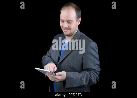 junger Mann dunklen grauen Anzug hält lächelnd tablet Stockfoto