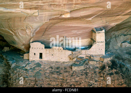 Die Mummy Cave Ruinen in den Canyon del Muerto ist Sqeezed in eine kleine Aussparung an der Unterseite eines majestätischen Felsen. Diese Klippen Stockfoto