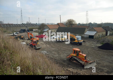 Grande-Synthe, Frankreich. 20. Januar 2016. Baumaschinen auf einer Freifläche in Grande-Synthe, Frankreich, 20. Januar 2016. Zwischen Autobahn und Bahn Bahnen ist ein neues Flüchtlingslager im Bau. Monatelang haben mehrere tausend Menschen in der nördlichen französischen Gemeinde unter elenden Umständen gelebt. Ärzte ohne Grenzen baut nun ein Flüchtlingslager mit beheizten Zelten. Foto: Sebastian Kunigkeit/Dpa/Alamy Live News Stockfoto