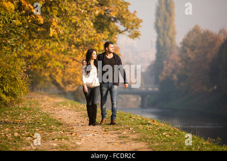 Paare, die im Wald durch den Wald außerhalb im Herbst Stockfoto