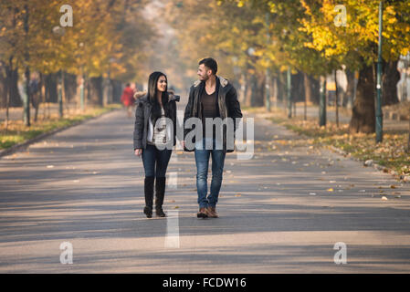 Paare, die im Wald durch den Wald außerhalb im Herbst Stockfoto