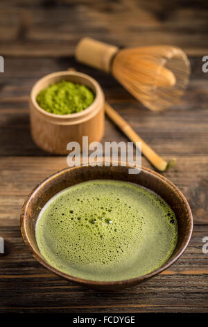 Bio green Matcha-Tee in einer Schüssel auf hölzernen Hintergrund Stockfoto