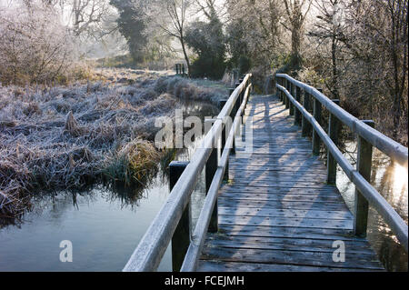 Eine Fußgängerbrücke über den Fluss-Test mit einem harten Morgen Frost an den Flussufern in Longparish, Hampshire, England Stockfoto