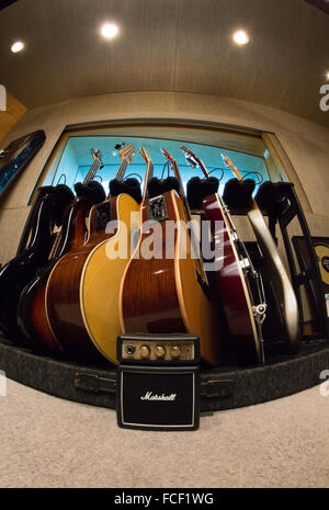E-Gitarren, akustische Gitarren und elektrischen Bassgitarren auf einem Gestell in einem Tonstudio Stockfoto