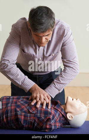 Mann mit CPR Technik auf Dummy In erste-Hilfe-Kurs Stockfoto