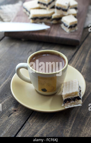 Waffel-Kuchen mit Schokolade und Kaffee am Tisch Stockfoto