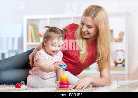 Mutter mit ihrem Kind spielen mit Holzblöcken zu Hause Stockfoto