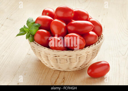 Korb mit frischen Tomaten und grüne Basilikumblätter Stockfoto