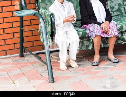 Großmutter und Enkel sitzen auf Outdoor-Schaukelsitz Stockfoto