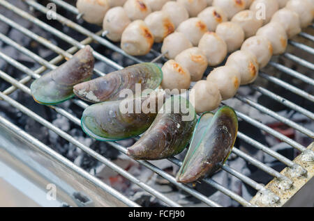 Frikadellen auf Metall Spieße und grüne Muscheln auf einem Grill gegrillt Stockfoto