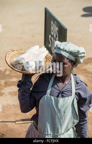 Straßenverkäufer verkaufen waren Menschen in den lokalen Bussen vorbei durch die Dörfer auf dem Weg heraus aus Kampala, Uganda, Afrika Stockfoto