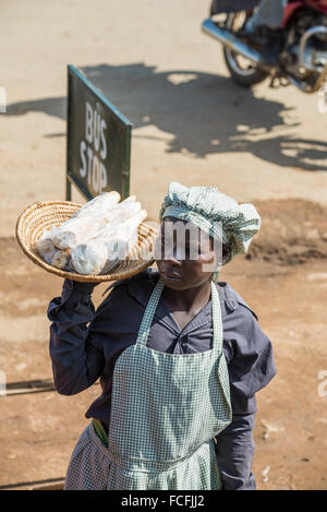 Straßenverkäufer verkaufen waren Menschen in den lokalen Bussen vorbei durch die Dörfer auf dem Weg heraus aus Kampala, Uganda, Afrika Stockfoto