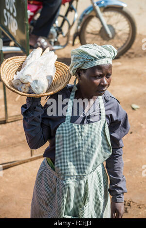 Straßenverkäufer verkaufen waren Menschen in den lokalen Bussen vorbei durch die Dörfer auf dem Weg heraus aus Kampala, Uganda, Afrika Stockfoto