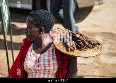 Straßenverkäufer verkaufen waren Menschen in den lokalen Bussen vorbei durch die Dörfer auf dem Weg heraus aus Kampala, Uganda, Afrika Stockfoto