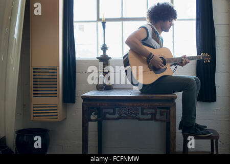 Loft-lebendigen. Ein junger Mann Gitarre spielen. Stockfoto