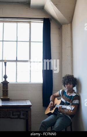 Loft-lebendigen. Ein junger Mann Gitarre spielen. Stockfoto