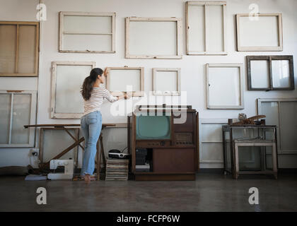 Loft-Dekor. Einer Frau hängen Bilderrahmen, Leinwände leer an der Wand. Stockfoto