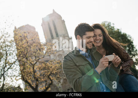 Ein paar in einer historischen Stadt, Blick auf ein smart Phone. Stockfoto