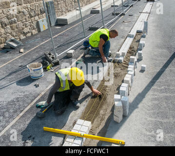 Bauarbeiter Maurer ebnet paviors Pfad Stockfoto