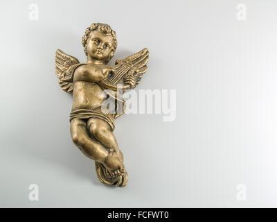 Gold Cherub legen flach auf weiße Fläche eine kleine Harfe zu spielen. Stockfoto