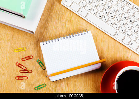 Tasse Kaffee Notizblock und Tastatur auf Holztisch Stockfoto