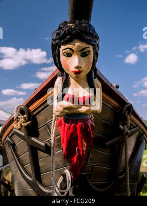 Im roten Kleid Skulptur an der Vorderseite des Piratenschiff Maiden mit gegen einen blauen Himmel mit Wolken verankern. Stockfoto