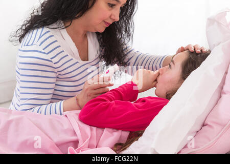Mutter kümmert sich um ihre kranke Tochter Stockfoto