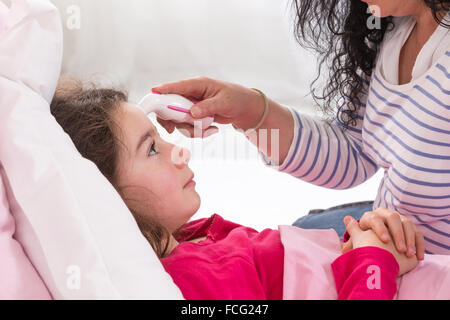 Mutter kümmert sich um ihre kranke Tochter Stockfoto