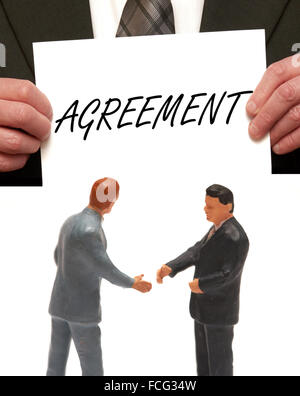 Vereinbarung-Konzept 2 Miniatur Figuren in Anzügen, die Hände schütteln Stockfoto