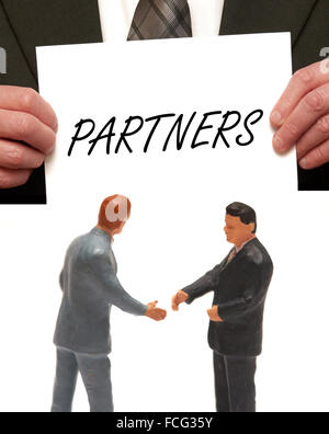 Partner-Konzept 2 Miniatur Figuren in Anzügen, die Hände schütteln Stockfoto