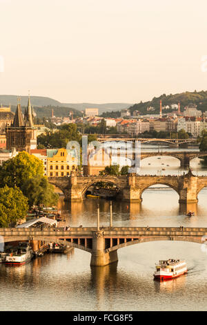 Alte steinerne Brücken über der Moldau mit einem Ausflugsboot sichtbar in der Stadt Prag, Tschechische Republik. Stockfoto