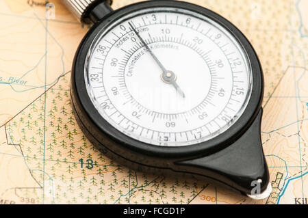 Karte-Rad auf einer Karte, verwendet zum Messen von Entfernungen mit unterschiedlichen Maßstäben. Stockfoto