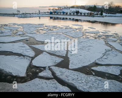 Boote am Lake Ontario mit schwimmenden Eisbrocken und Schnee in Oakville, Ontario, Kanada im Winter abgedeckt. Stockfoto